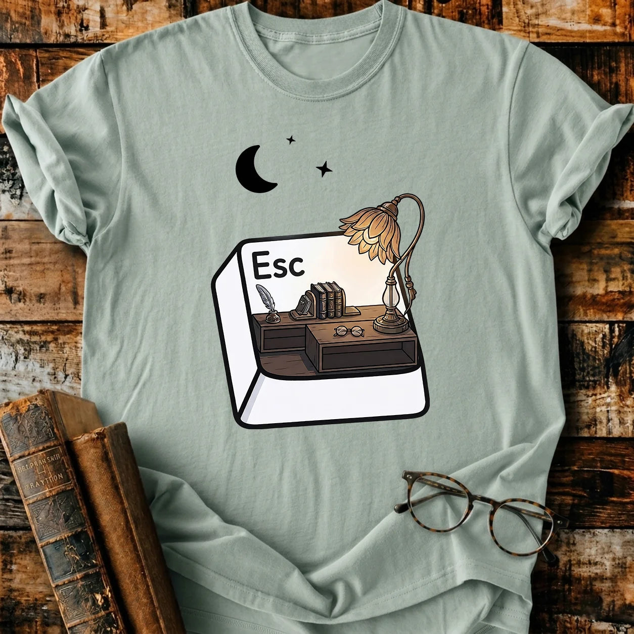 Comfort Colors Escape T-shirt, light green, with a desk inside an "Esc" key, books, lamp, and moon design.