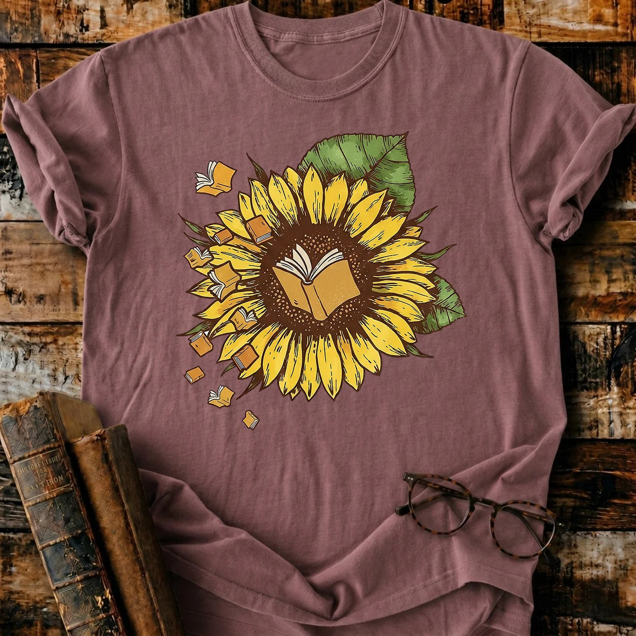 Garment-dyed Comfort Colors unisex t-shirt with a sunflower and flying books design.